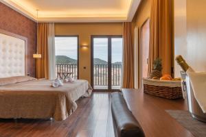 a hotel room with a bed and a balcony at Fuente del Miro in Valderrobres