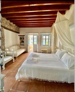 1 dormitorio con 1 cama blanca grande y techo de madera en Apanemo en Grikos