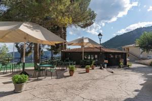 a patio with tables and chairs and umbrellas at Casas Rurales & SPA VegaSierra in Bogarra