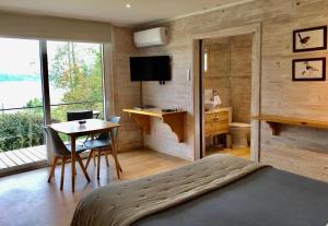 a bedroom with a bed and a desk and a table at Amukan Lodge in Panguipulli