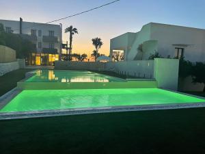a swimming pool in front of a house at Tuo Hotel in Polignano a Mare