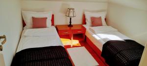 a small room with two beds and a table with a lamp at Apartman President in Vrnjačka Banja +2 photos
