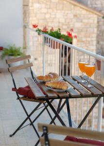 einen Tisch mit zwei Gläsern Orangensaft und Croissants in der Unterkunft Apartment Nona - Center, 150 meters from the beach in Supetar