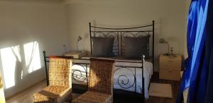a bedroom with a bed with two wicker chairs at Ferienhof Ziegler Salbei in Baiersbronn