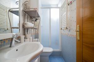ein Badezimmer mit Waschbecken, Toilette und Spiegel in der Unterkunft Cosy Apartment Malasaña in Madrid + 21 Fotos