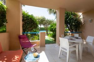 a living room with a table and chairs and a patio at Las Dunas, bajo, 2 dormitorios, 25m del mar, by Bookindenia in Denia