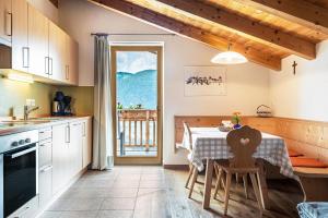 a kitchen with a table and a dining room at App Dolomiten Winklerhof in Villandro