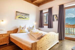 1 dormitorio con cama de madera y ventana en App Dolomiten Winklerhof, en Villandro