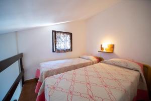 Habitación con 2 camas y ventana en Appartamento Laura en Porto Azzurro