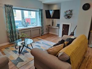 a living room with a couch and a table at NEW Fabulous 2BD Maisonette Dunfermline, Fife in Dunfermline