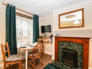 a living room with a table and a fireplace at Page-turner's Cottage in Hereford