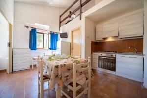 a kitchen with a table and chairs in a room at Appartamento Laura in Porto Azzurro