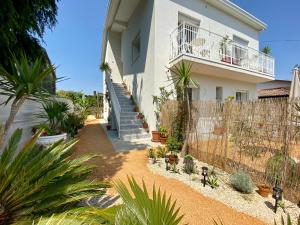 a house with a fence and a bunch of plants at Pathos Guest House in Quarto dʼAltino