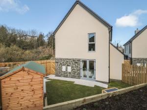 a detached house with a garden and a fence at High Tide House in Craster