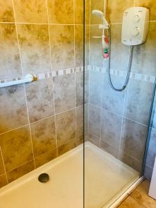 a shower with a glass door in a bathroom at The Cottage, Winley Farm in Bromyard