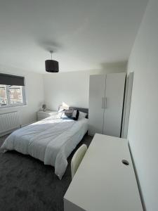 a white bedroom with a bed and a white cabinet at Double room with private bathroom in Basingstoke in Basingstoke