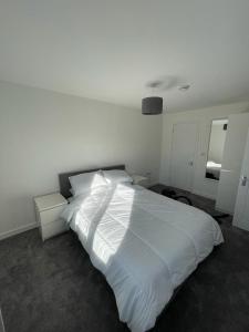 a bedroom with a large white bed and a mirror at Double room with private bathroom in Basingstoke in Basingstoke