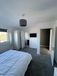 a white bedroom with a large bed in a room at Double room with private bathroom in Basingstoke in Basingstoke