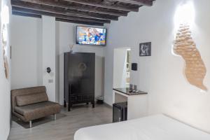 a living room with a chair and a tv on the wall at iRooms - Spanish Steps in Rome