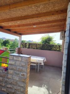 eine Terrasse mit einem Tisch und einer Steinmauer in der Unterkunft Apartment Mario in Pula