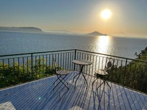 balcón con mesa, sillas y vistas al océano en Punta Lingua Relais- Room 1 Sunrise Terrace, en Procida