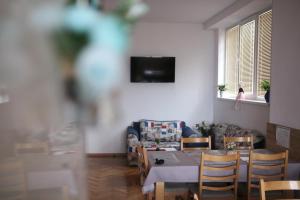 a dining room with a table and chairs and a television at Gile Guest House in Veliko Tŭrnovo