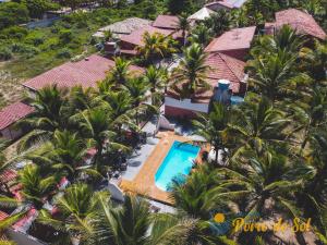 an aerial view of a resort with a pool and palm trees at Pousada Porto do Sol in Nova Viçosa