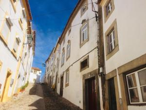 un callejón en un casco antiguo con edificios blancos en Casa da Vila, en Castelo de Vide