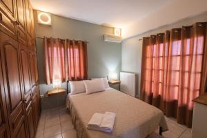 a bedroom with a bed with two towels on it at Villa Georgina B&B in Katakolo