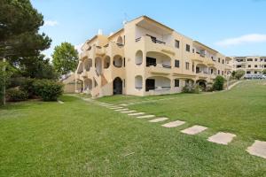 a large building with a grass yard in front of it at Alvor Quinta Nova in Alvor