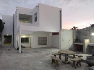 a white building with benches in front of it at Monoambiente Estela in San Pedro