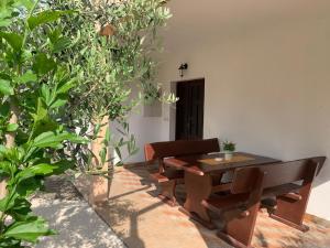 a table and bench in a courtyard with trees at Apartman ABO*** in Komin