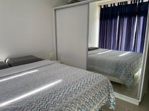 a bedroom with a mirror and a bed and a window at Departamento loft con estacionamiento in Asuncion