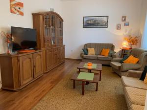 a living room with a large entertainment center and a television at Apartman ABO*** in Komin