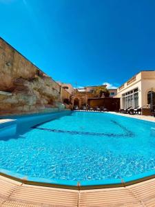 een groot zwembad met blauw water bij Velver Mansion, Malta - Luxury Villa with Pool in Naxxar