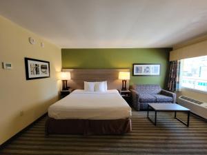 a hotel room with a bed and a chair at Quality Inn Flamingo in Atlantic City +16 photos