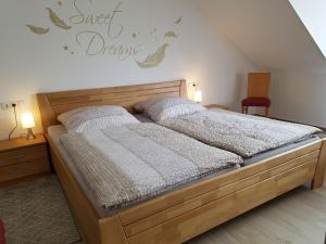 1 dormitorio con 1 cama de madera y 2 almohadas en Ferienhaus MoselCharme, en Alken