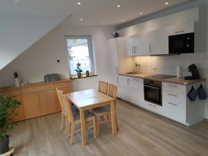 uma cozinha com uma mesa e cadeiras numa cozinha em Ferienhaus MoselCharme em Alken