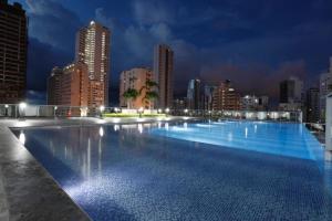 a large swimming pool with a city skyline at night at Lujoso Apartamento en Bocagrande in Cartagena de Indias