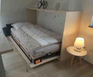a small bed in a room with a lamp and a table at Ferienhaus MoselCharme in Alken
