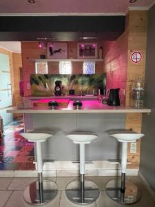 a bar with three stools in front of a counter at La Souricière in Silenrieux