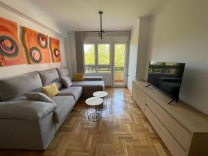 a living room with a couch and a flat screen tv at Apartamento Turistico Mirador de Valdellera I in Posada de Llanes