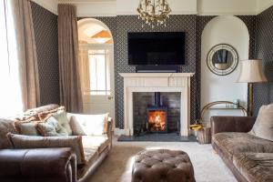 a living room with a fireplace with a tv above it at Wressle Grange (farmhouse) in Selby