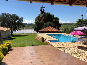 a house with a swimming pool and a patio at Pedacinho do Paraiso in CÃ¡ssia