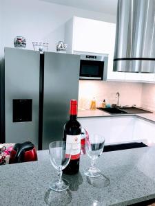 a bottle of wine and two wine glasses on a kitchen counter at EIFFEL TOWER PENTHOUSE in Paris