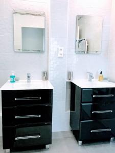 a bathroom with two sinks and a mirror at EIFFEL TOWER PENTHOUSE in Paris