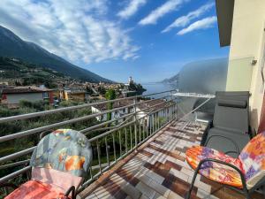 balcón con sillas y vistas al agua en Appartamenti Villa Eden, en Malcesine