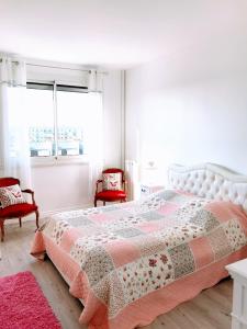 sypialnia z łóżkiem i 2 czerwonymi krzesłami w obiekcie EIFFEL TOWER PENTHOUSE w Paryżu