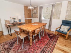 uma sala de jantar com uma mesa de madeira e cadeiras em Widgeons Keel em Falmouth