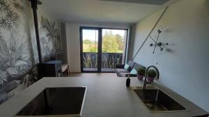 a living room with a sink and a kitchen with a couch at Le Makalle in Dalhem